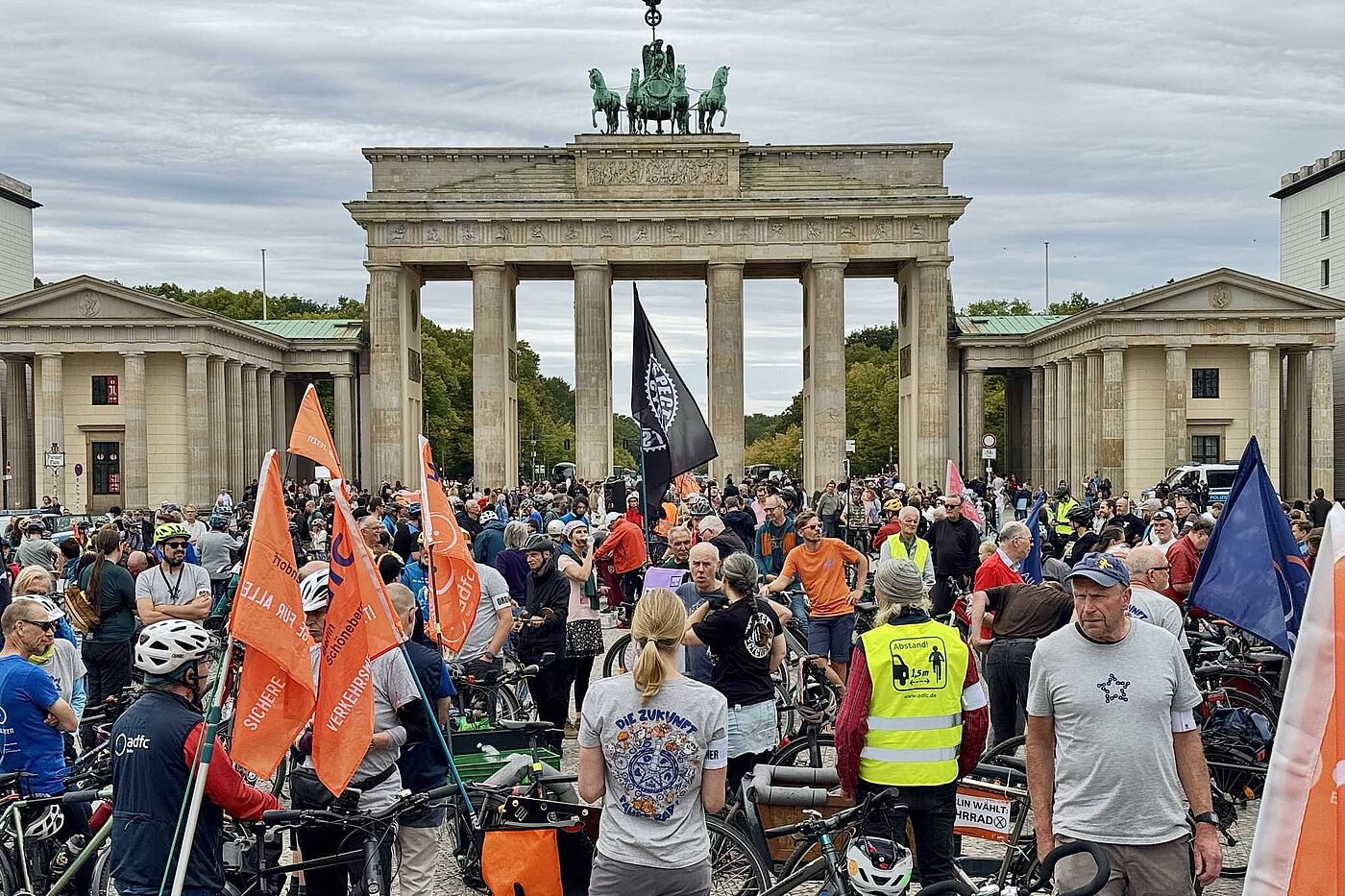 Menschen mit Fahrrädern und Fahnen vor dem Brandenburger Tor