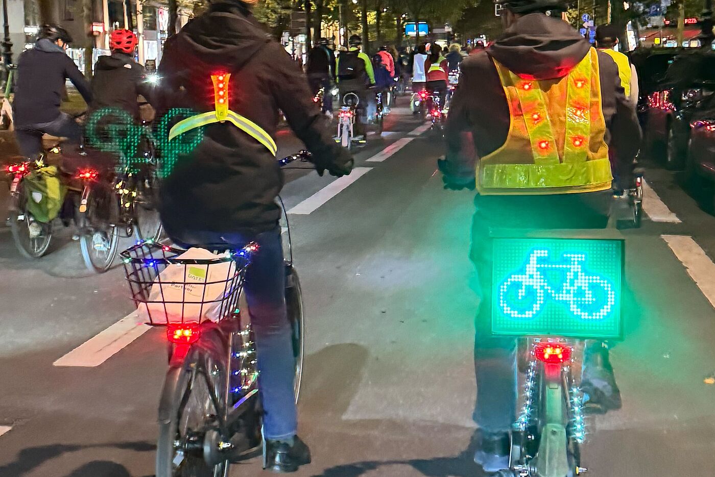 Lichterfahrt 2025 Radfahrende mit Leuchtschild auf Gepäckträger auf dem ein Fahrrad dargestellt ist