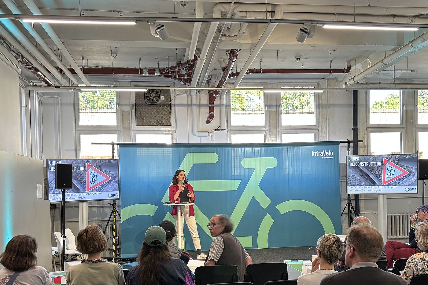 Marlene Alber VELO 2025 Frau hält einen Vortrag vor einem Fahrradbanner bei der VELO Messe