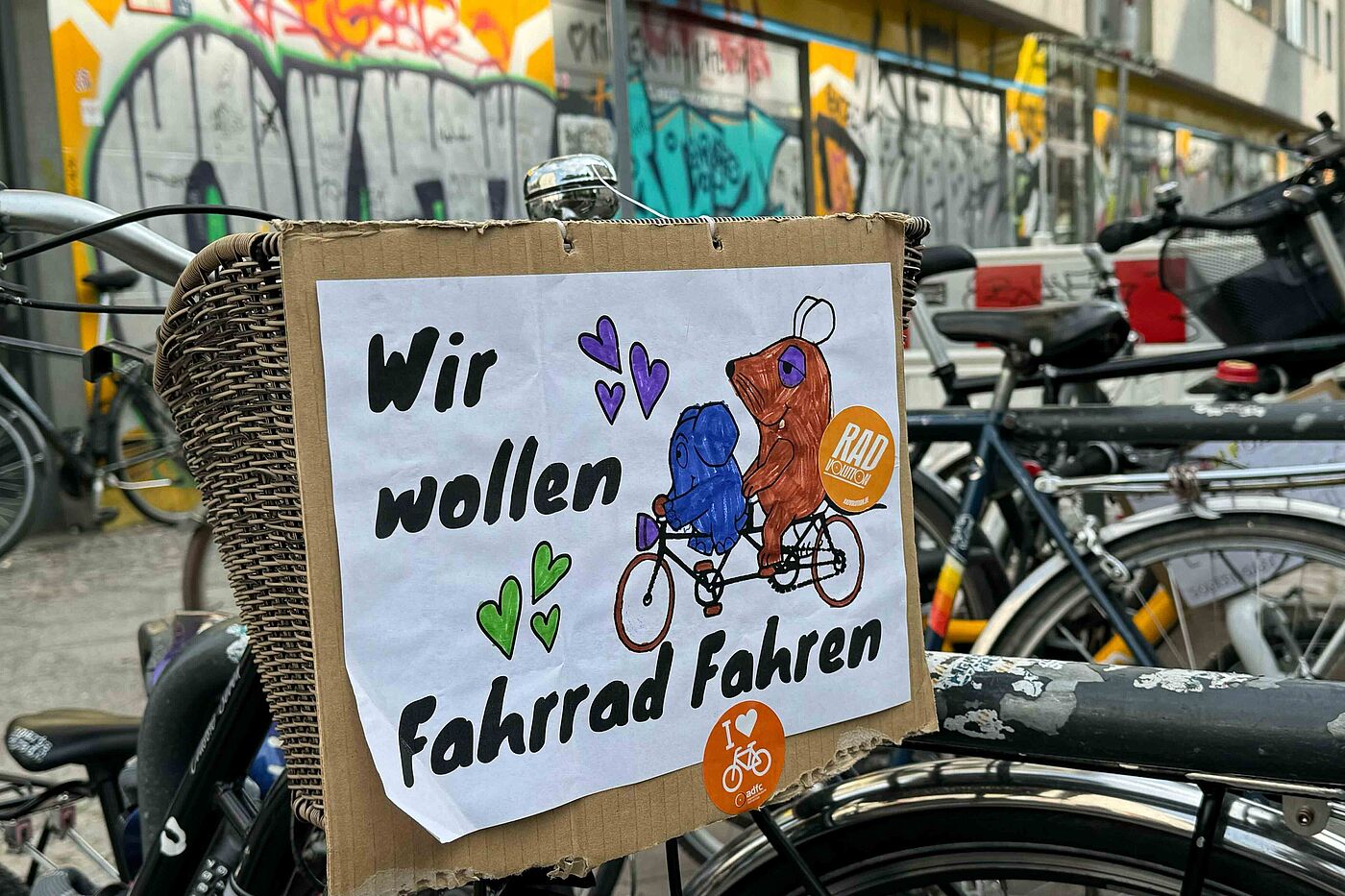 Kidical Mass 2024 Selbstgemaltes Schild an Fahrrad mit der Maus und Elefanten auf dem steht: Wir wollen Fahrrad fahren