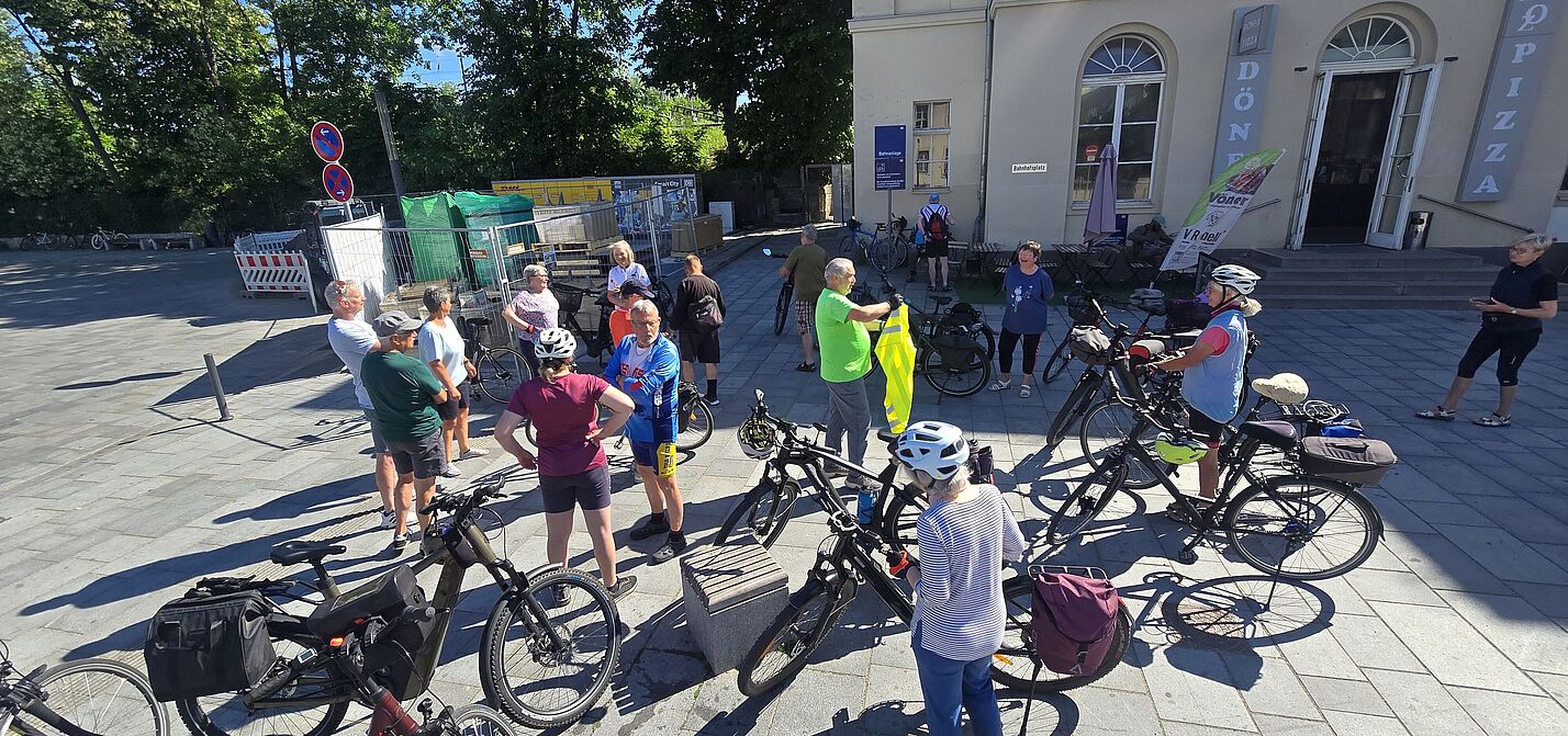 Radler stehen am Bahnhofsvorplatz